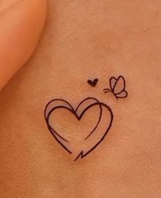 a small heart tattoo on the back of a woman's stomach