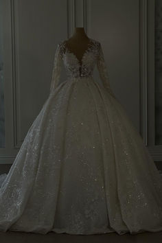 a white wedding dress with long sleeves and sequins