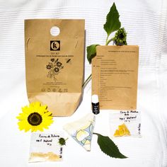 a brown paper bag sitting on top of a table next to a yellow sunflower