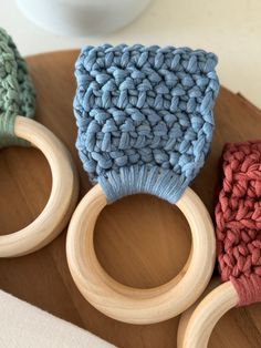 three crocheted wooden toys sitting on top of a wood table next to each other