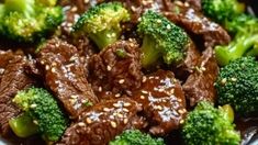 beef and broccoli with sesame seeds in a bowl