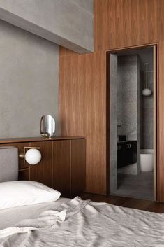 a bedroom with wood paneling and white linens on the bed, along with an open closet