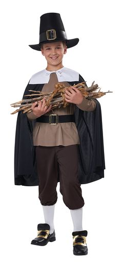 a young boy dressed in a pilgrim costume and holding some twigs while wearing a black hat