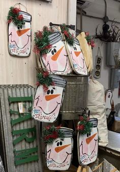 christmas decorations are hanging on the wall in an old fashioned shop, with snowmen painted on them