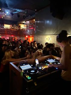 a dj mixing in front of a large group of people