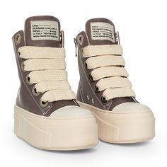 The sneakers are high-top platform-style shoes with a dominant color scheme of chocolate and cream. They feature a thick, cream-colored rubber sole with layered detailing that gives the shoe a bold and chunky silhouette. The upper part of the sneakers is primarily chocolate, constructed with leather material. The design includes metal eyelets for the laces, which are cream-colored and chunky, complementing the sole. Christian Zerotre, Chunky Tennis Shoes, Doctor Shoes, Shoes Png, Curvy Casual Outfits, Pretty Shoes Sneakers, Shoes Outfit Fashion, Chocolate Leather, Chunky Shoes