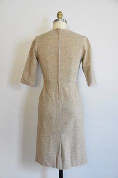 "Vintage 1950s wool dress. Oat colored wool. V high collar with decorative buttons, seamed bust, and long sleeves. Straight skirt with back metal zipper closure. Unlined. *item has not been dry cleaned State of garment | excellent. Measurements ✂--- Best fit | Small/ Medium Bust | up to 35\" Shoulders | 14\" Shoulder to waist | 15\"\" Sleeves | 15\" Waist | 26.5- snug 27\" Hips | up to 38\" Total length (shoulder to hem) | 39\" Tag | ★★Visit The Shop★★ http://www.etsy.com/shop/seaofvintage ➸ Fin Tea Party Bridal Shower, Peach Dress, Hip Ups, Rayon Dress, Decorative Buttons, Straight Skirt, Wool Dress, Metal Zipper, Wool Cardigan