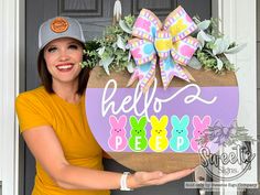 a woman holding up a sign that says hello peep with easter bunnies on it