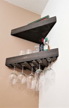 several wine glasses are lined up on a shelf with a bottle and glass holder attached to it