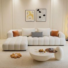 a living room with white furniture and art on the wall