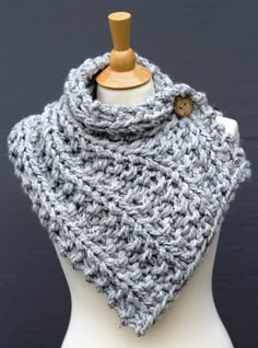 a gray knitted cowl on a white mannequin with a wooden button