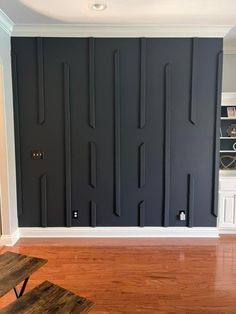 an empty room with black painted walls and wooden floors