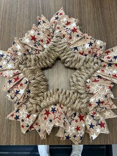 a wreath made out of burlocks with stars on the front and sides, sitting on top of a wooden table