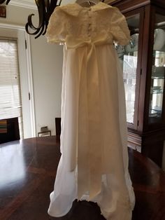 "FREE SHIPPING IN THE U.S. and reduced shipping rates for International orders. This beautiful gown is grandmother's wedding dress conversion, but it can be made new from similar fabric from my shop. Satin bodice with puffed sleeves and a scalloped lace edge. Organza skirt also has the scalloped lace edge. Beautiful large collar in the front with a bow (optional) Satin ribbon ties in the back of the waist. Bridal looping and satin buttons close the back. Matching bonnet included. Gown is made he Cream Floor-length Gown For Ceremony, Regency Style Empire Waist Wedding Gown, Baptism Dress With Fitted Bodice, Ball Gown Shape, Baptism Dresses With Fitted Bodice In Ball Gown Shape, Fitted Bodice Ball Gown For Baptism, Ceremony Floor-length Gown With Lace Trim, Floor-length Dresses With Lace Trim For Ceremony, Ceremony Floor-length Dress With Lace Trim, Floor-length Lace Trim Gown For Ceremony