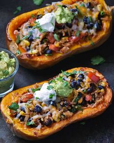 two stuffed sweet potatoes with black beans, guacamole and avocado