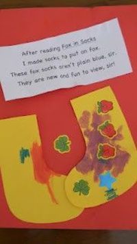 a child's handmade christmas stocking craft on a red paper with a note attached to it