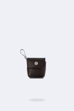 The Avery AirPod Pouch features our classic black pebbled leather with silver tone details and a lightweight leather fold-over snap closure. This must-have accessory connects easily to any Bandolier or pouch set and adds a chic, functional solution to carrying your easy-to-lose AirPods! AirPod: Pouch 2” wide x 2 ⅛” high x 1” deep AirPod Pro: Pouch 2.5” wide x 2” high x 1” deep GENUINE LEATHER - Luxurious pebble leather beautifully molds to your AirPod case and other items. METAL CONNECTOR - desi Everyday Black Bag With Key Clip, Modern Travel Coin Purse With Key Clip, Modern Coin Purse With Key Clip For Travel, Leather Travel Bags With Key Clip, Black Bag With Key Clip For Everyday Use, Black Bags With Key Clip For Everyday Use, Versatile Travel Coin Purse With Key Clip, Black Travel Coin Purse With Key Clip, Black Coin Purse With Key Clip For Travel