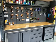 a workbench with many tools on the wall and pegboard in front of it