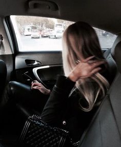 a woman sitting in the back seat of a car