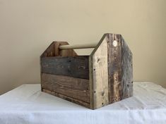 an old wooden tool box sitting on top of a white sheet