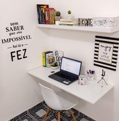 a laptop computer sitting on top of a white desk next to a book shelf filled with books