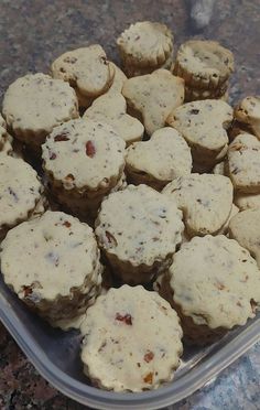 a plastic container filled with muffins on top of a counter