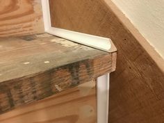 a close up of a wooden bench with white trim