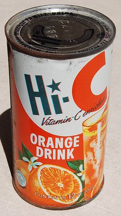 an orange drink can sitting on the ground