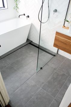 a bathroom with a shower, sink and bathtub next to a window in the corner