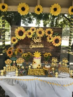 a table with sunflowers and cupcakes on it