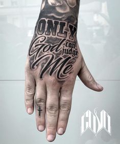 a man's hand with the words only god can judge me tattooed on it