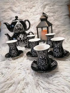 black and white porcelain tea set with matching saucers, cups and saucers on a furnishing