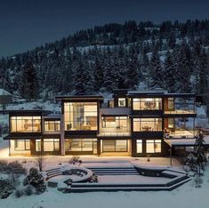 a large modern house in the snow at night