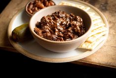 a bowl of chili and crackers on a plate