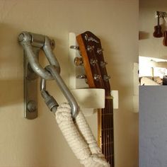 a guitar hanging on the wall next to a hook with an electric guitar in it