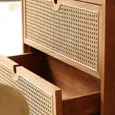 the drawers are made out of wood and have rattan weaved panels on them