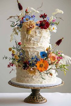 a white cake topped with lots of colorful flowers