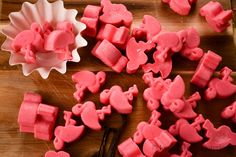 some pink gummy bears sitting on top of a wooden table