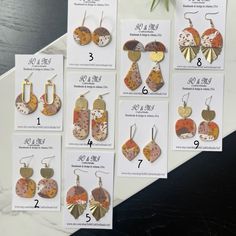 several different types of earrings are displayed on the table with price tags attached to them