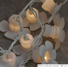 some white lights that are sitting on the ground with flowers attached to each light bulb