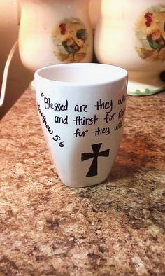 two coffee mugs sitting on top of a counter with words written in black and white