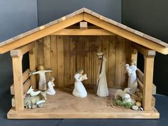 a wooden nativity scene with figurines in it