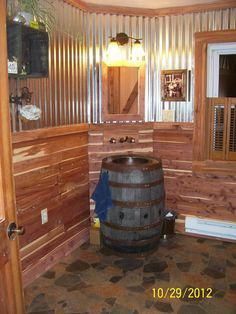 a wooden barrel sitting in the corner of a bathroom next to a sink and mirror