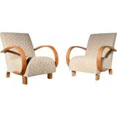 a pair of art deco chairs with wooden arms