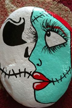 a painted rock with a woman's face on it