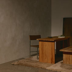 a wooden table with two chairs next to it and a rug on the floor in front of it