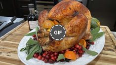 a turkey on a plate with cranberries and oranges next to a bottle of wine