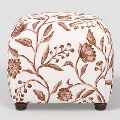 a white ottoman with brown flowers on it