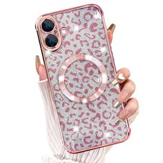 a person holding up a pink and silver phone case with leopard print on the back