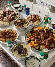 a table topped with lots of food on top of a white counter covered in sauces and condiments